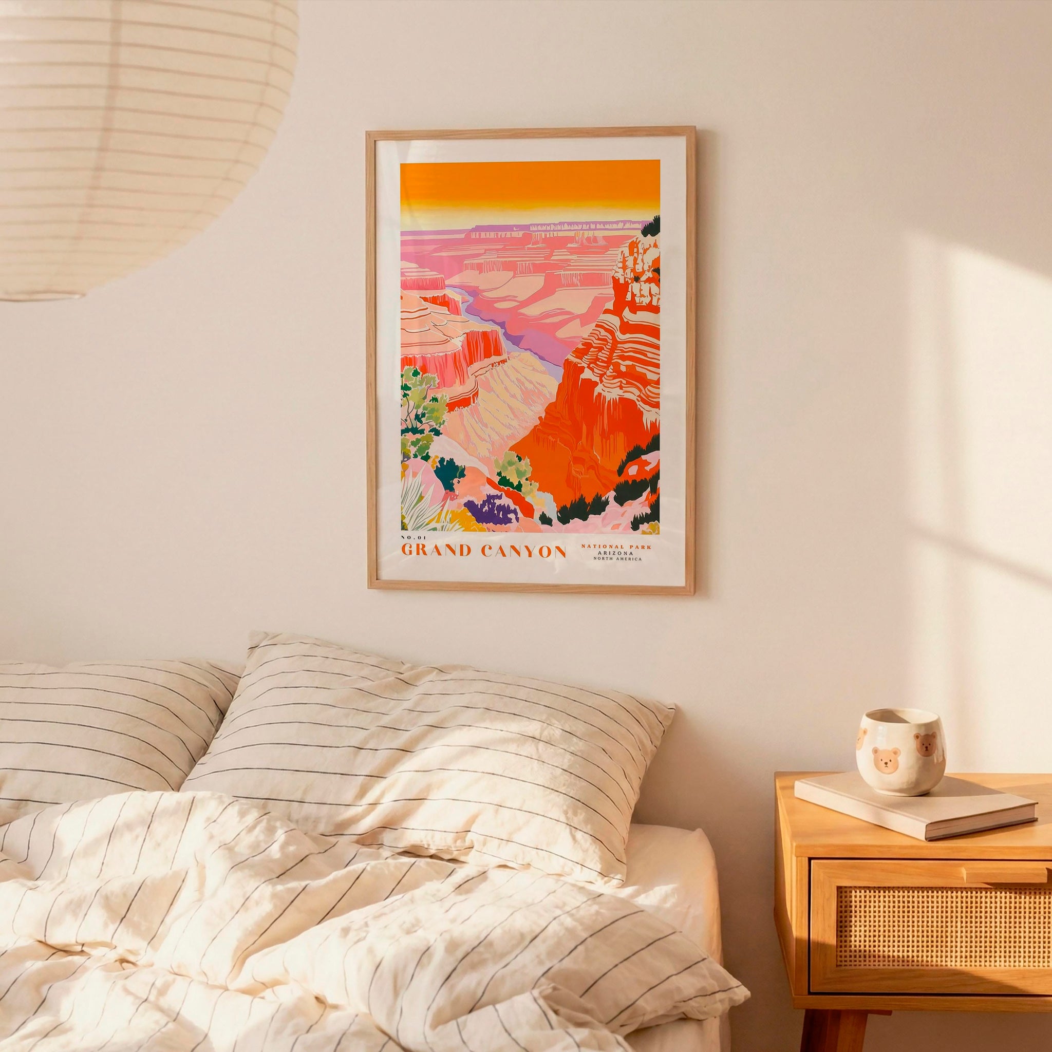 a bedroom with a bed, a nightstand, and a framed poster of the Grand Canyon hanging on the wall.