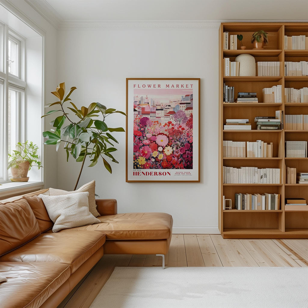 a cozy living room with a large window, a comfortable leather couch, a bookshelf filled with books, and a framed poster of a flower market hanging on the wall.