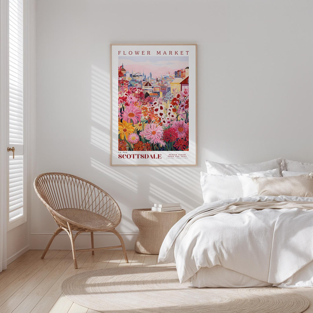 a bedroom with a bed, a wicker chair, and a framed poster of a flower market in Edinburgh, Scotland.