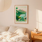 a bedroom with a framed poster of a tropical beach landscape hanging on the wall above a bed with striped pillows.