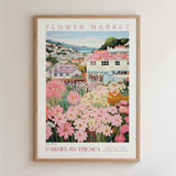 The image is a framed poster depicting a flower market in a coastal town, with colorful flowers and buildings in the background.