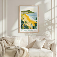 a framed poster of a beach scene with palm trees and a mountain in the background, hanging on a wall above a white couch with a blanket draped over it.