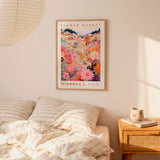 a bedroom setting with a framed poster of a colorful floral scene hanging on the wall above a bed with striped pillows.