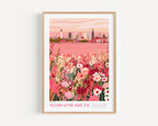 The image is a framed poster depicting a cityscape with a field of flowers in the foreground.