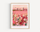The image is a framed poster depicting a cityscape with a field of flowers in the foreground.