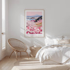 A bedroom with a large bed, a woven chair, and a framed poster of a floral landscape hanging on the wall.