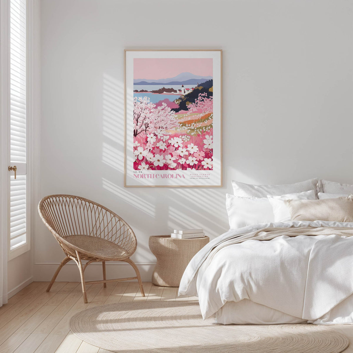 A bedroom with a large bed, a woven chair, and a framed poster of a floral landscape hanging on the wall.