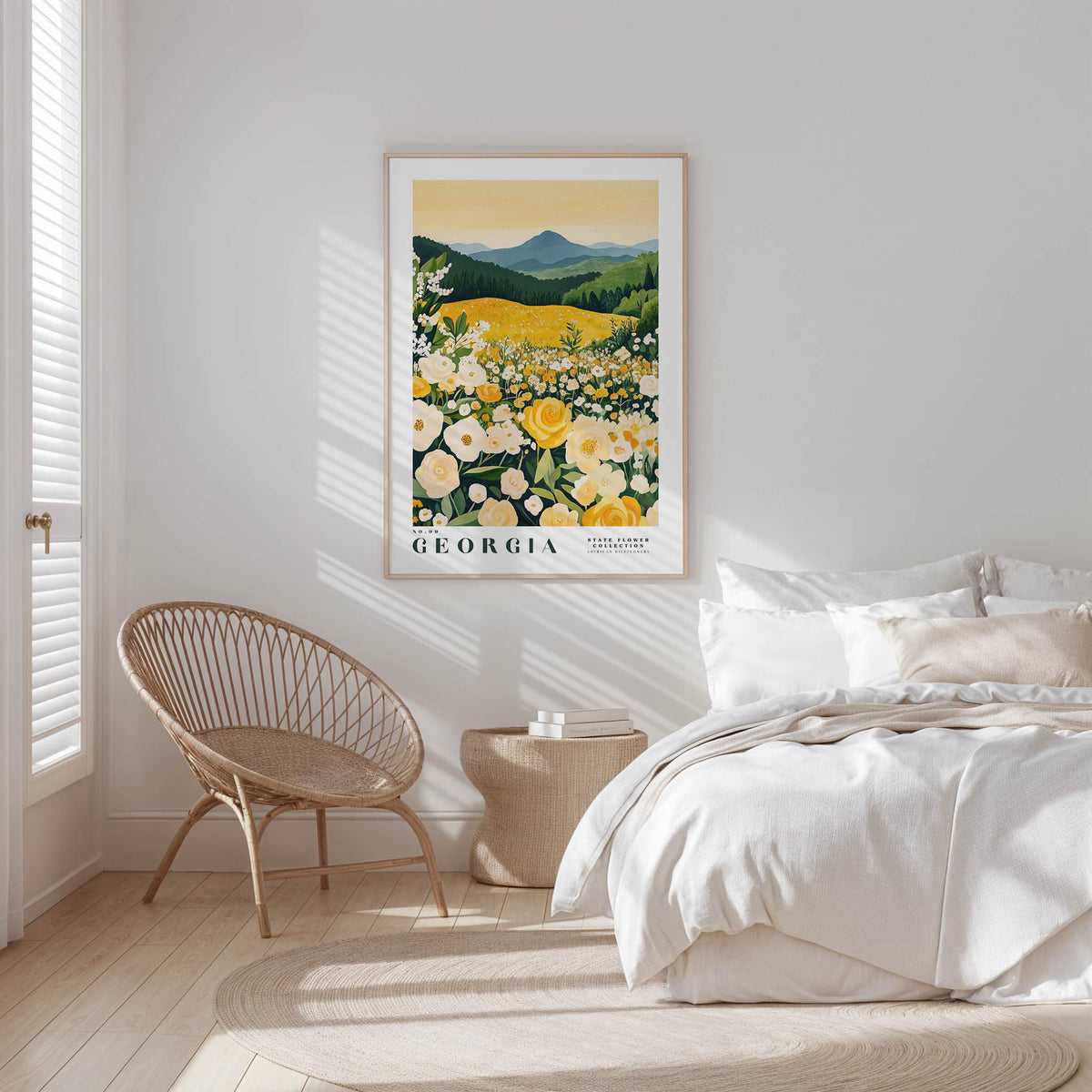 a bedroom with a large framed poster of a field of flowers hanging on the wall, a wicker chair, and a bed with white bedding.