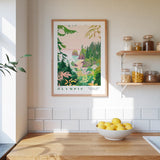 a kitchen scene with a framed poster of a tropical landscape hanging on the wall above a wooden countertop. On the countertop, there is a bowl of lemons and a plant. The kitchen also has shelves with various jars and containers, and the walls are tiled.