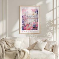 a poster of a flower market in Miami hanging on a wall above a white couch with a blanket draped over it.