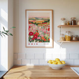 a kitchen counter with a bowl of lemons, a framed poster of a field of flowers, and a shelf with jars and containers.