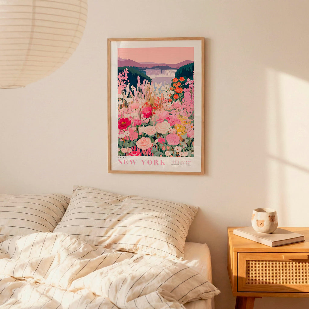 a bedroom scene with a framed poster of a colorful floral landscape hanging on the wall above a bed with striped pillows.