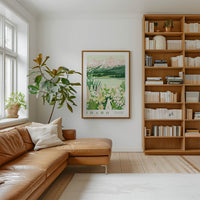 a cozy living room with a large window, a comfortable leather sofa, a wooden bookshelf filled with books, and a framed poster of Idaho mountains hanging on the wall.