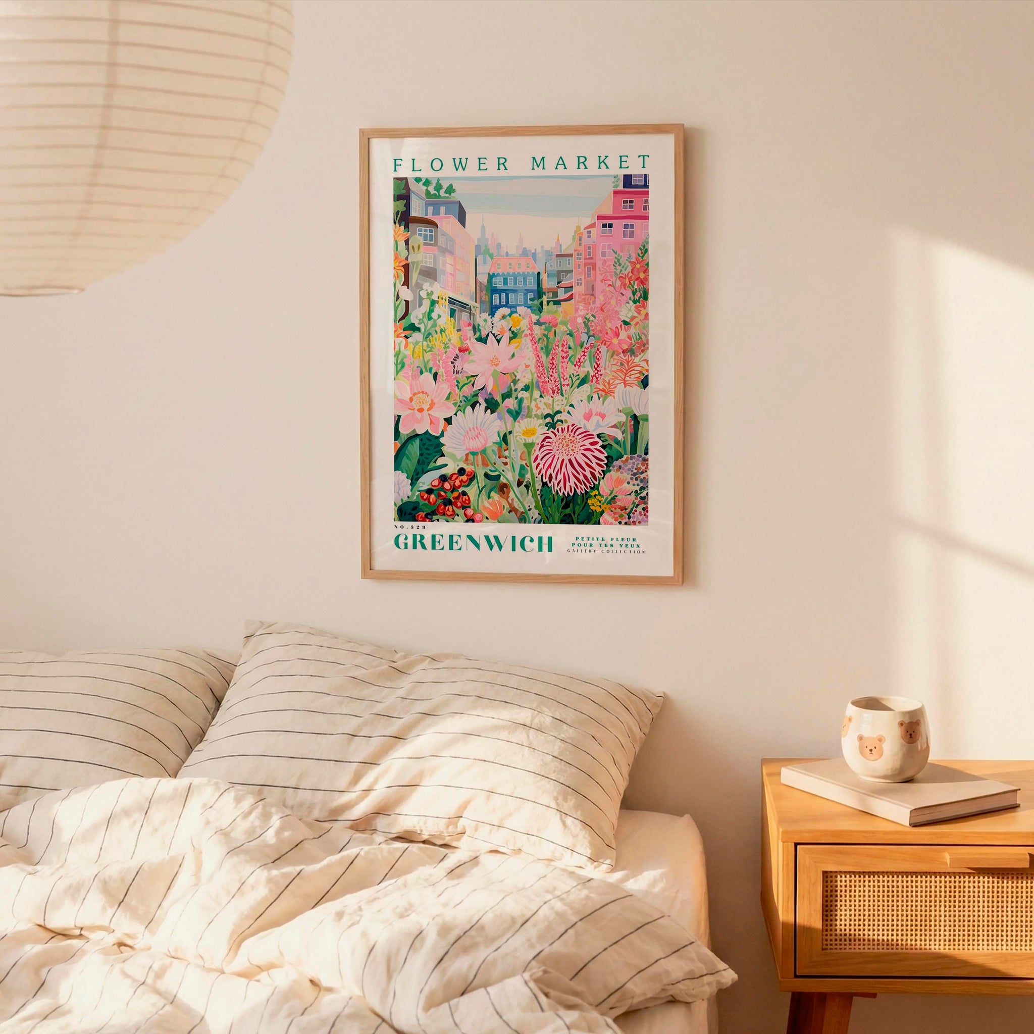 a bedroom setting with a framed poster of a flower market hanging on the wall above a bed with striped pillows.