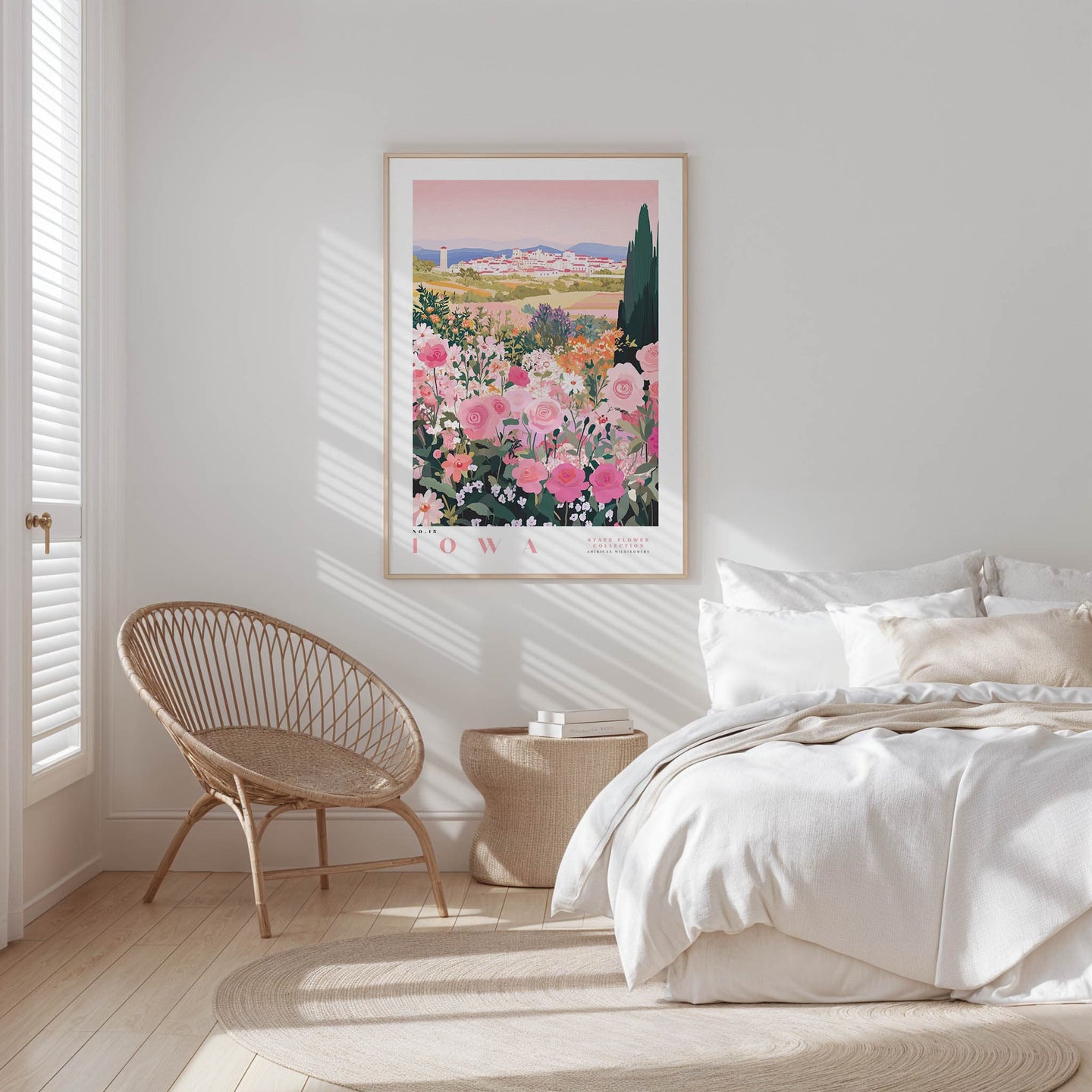 A bedroom with a large floral print hanging on the wall, a woven chair, and a bed with white bedding.