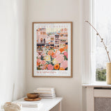 a framed poster of a colorful illustration of a flower market in Wilmington, North Carolina, hanging on a wall.