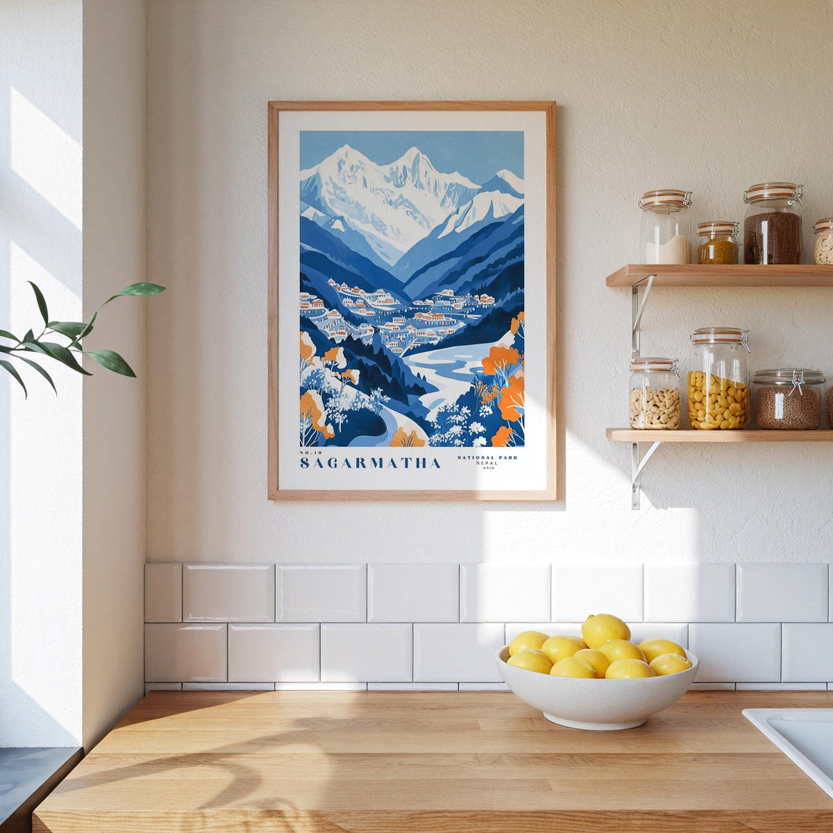 a kitchen counter with a bowl of lemons, a framed poster of Nagarmattha, and shelves with jars and bottles.