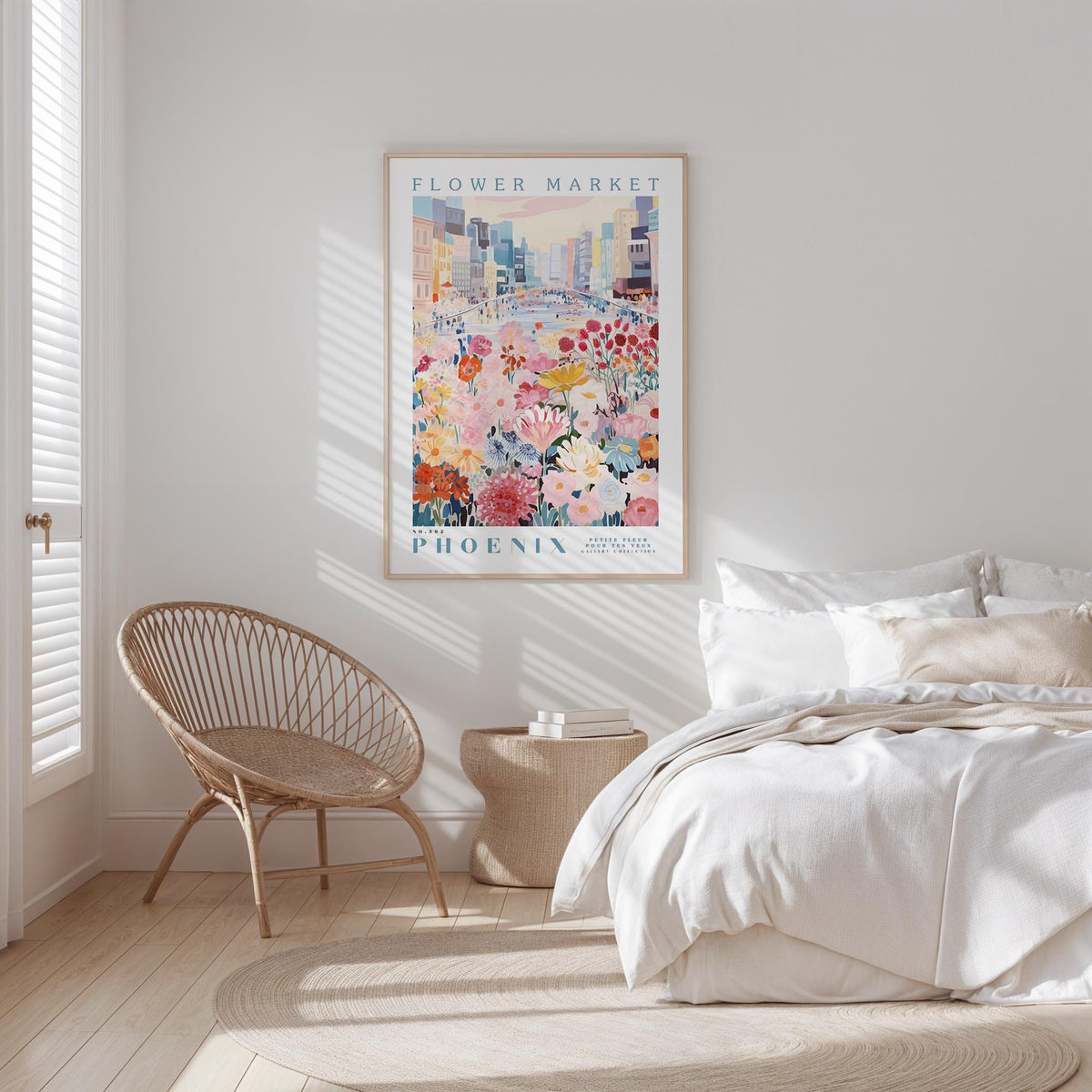 a bedroom with a bed, a woven chair, and a framed poster of a cityscape with flowers hanging on the wall.