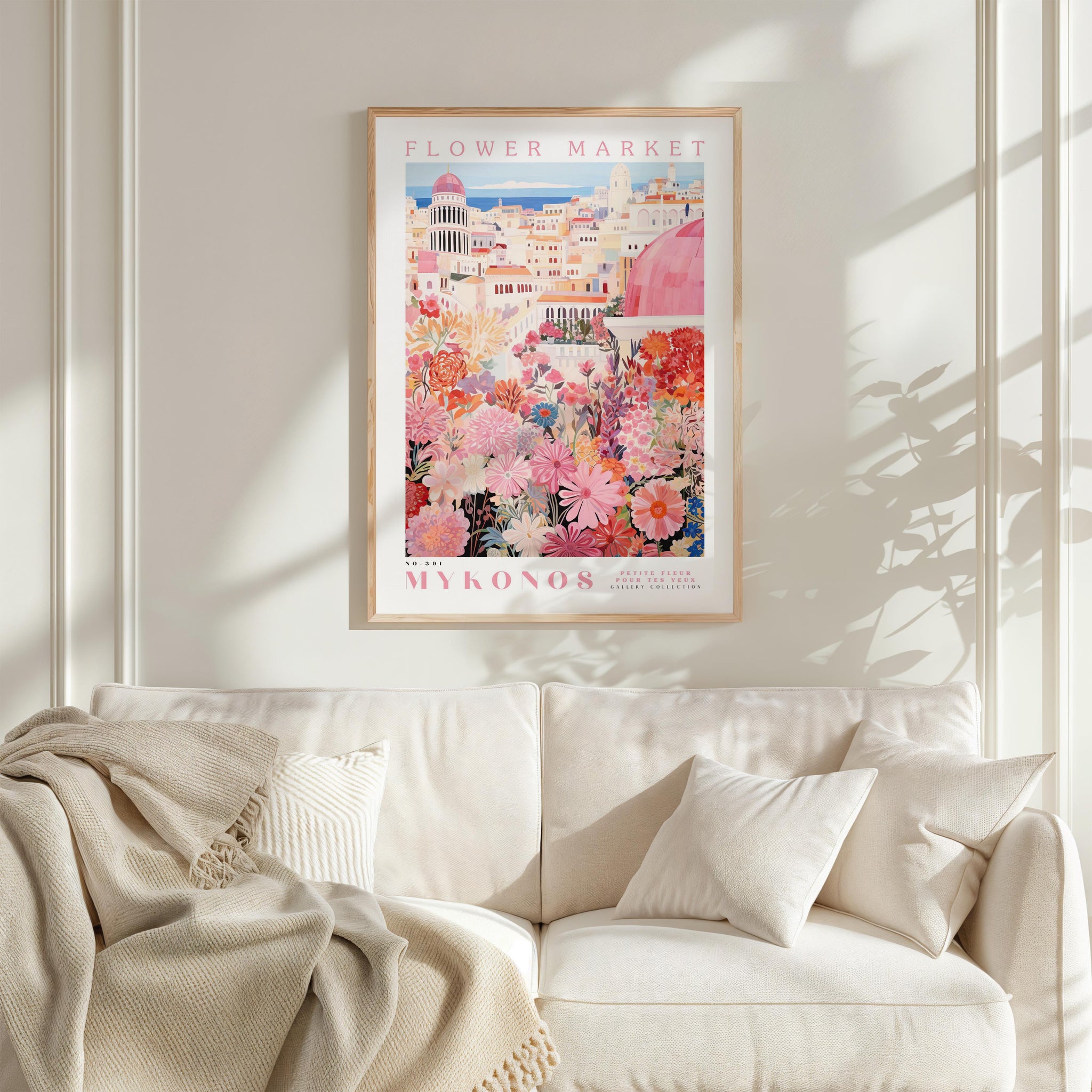 a cozy living room with a white sofa and a framed poster of a colorful floral scene hanging on the wall above it.