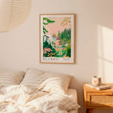 a bedroom scene with a framed poster of a tropical landscape hanging on the wall above a bed with striped pillows.