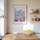 a framed poster of a cityscape with a flower market in the background, hanging on a wall above a wooden counter with a bowl of lemons.