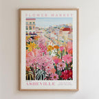 The image is a framed poster depicting a vibrant and colorful flower market in the city of Asheville, North Carolina.